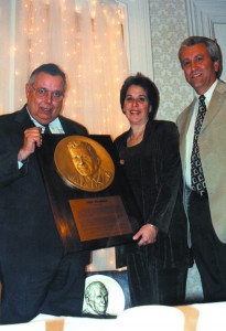 Philip W. Engle, former manager of Teterboro Airport, presents the Hall of Fame plaque for inductee Fred Feldman to his niece, Sue Yanitelli, as her husband Richard, looks on.