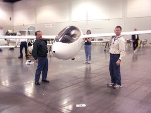 Greg Cole (right), Neva Cole (rear), and Doug Taylor (left) demonstrate how easy it is to lift the 155-lb. empty weight of the SparrowHawk carbon fiber sailplane offered by Windward Performance LLC.