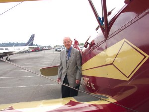 Clayton Scott poses with this 1928 Travel Air (at Boeing Field), a plane similar to the 1927 Travel Air he flew for Vern Gorst’s Seattle Flying Service in 1928. At the left is the twin-engine Piper Aerostar he flew into Boeing Field for his 100th birthday