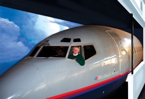 Artist Rick Broome shows off the fully restored cockpit of the Boeing 727-222A he has had installed in his backyard. His new studio was built around the 727 and the airliner is now completely enclosed indoors.