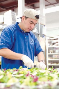 A staff member prepares the ingredients for one of Rudy’s mouthwatering meals. The catering company prides itself on the quality of its 200-member staff.