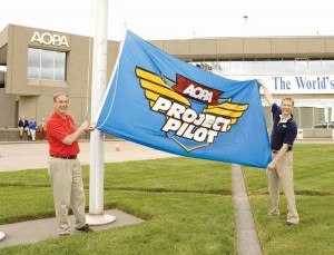 Phil Boyer, president of AOPA, and Erik Lindbergh, AOPA Project Pilot spokesman, raise the Project Pilot flag to launch the AOPA program intended to attract more people to general aviation.