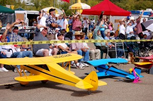 Planes used in the radio controlled aircraft demonstration sat on the ramp while spectators watched the real airplanes perform overhead.