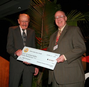 NAHF enshrinee Bob Hoover hands Dr. Richard Hallion his 2006 Combs Gates Award, a $20,000 check rewarding his aviation history research.