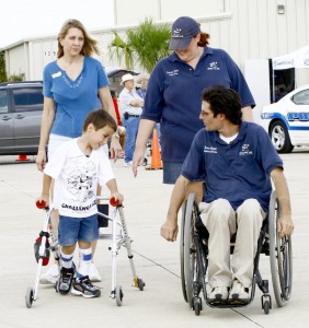 Linda Lauchner (left), with son Jason, on the ramp with Theron Wright, Challenge Air chief wheelchair aviator, and volunteer Catrina Clack. Although Wright was paralyzed in a work-related accident, Rick Amber inspired him to fly.