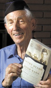 Lyle Sladek holds his daughter’s book. Now 80, he’s still actively involved with his 40-year career as a mathematics professor.