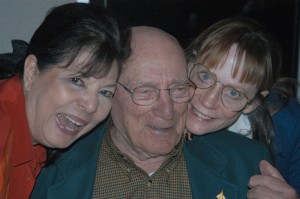 Bea Khan Wilhite (left) and Babette Andre sing “Happy Birthday” to Bill Bower on his 90th birthday.