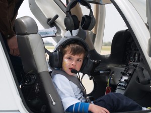 Tommy Krisp had his face painted before his flight. The pilots enjoy working with all the young copilots, but it’s an added blessing when a child really gets into flying. The pilot helps the copilot make left and right turns.
