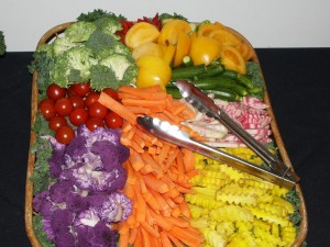 A colorful vegetable tray includes unusual items like purple cauliflower and yellow tomatoes, for an added bit of zest.