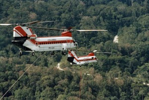 Two of Columbia Helicopters’ models, a Model 234 Chinook, left, and a Vertol 107-II, fly over Papua New Guinea on a petroleum exploration project.
