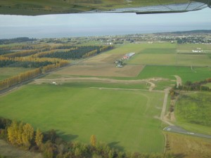 Looking north toward the Strait of Juan de Fuca, Discovery Trail Farm is in the foreground, with 30 acres at the end of the runway, at lower right. Home sites are along the entrance road to the development.