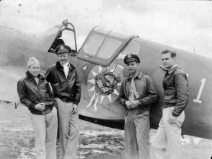 L to R: John Alison, Maj. Tex Hill, Ajax Baumler and Mack Mitchell, at Kunming in July 1942, pose in front of a P-40 bearing the original 23rd Fighter Group logo, a Disney tiger wearing an “Uncle Sam” hat, tearing through a Chinese Sun.