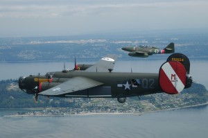 Cruising in formation over Whidbey Island, with Paine Field in the background, this B-24 Liberator and Me 262 Stormbird present an unusual view of these World War II adversaries.