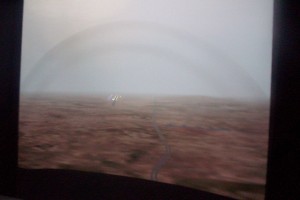 The large projected display seen through the FTD windshield shows major local terrain, and in this case, ground haze selected by the instructor.