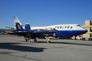 A United Airlines 747 dwarfs Blue Angel number 6 at the maintenance facility housing the Blue Angels team, miles away from show center.