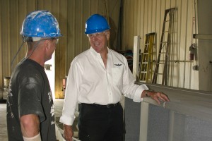 Superior quality is a top requirement for EagleSpan. Jerry Curtis (right) discusses a finished beam with Mark Dodson, production paint line manager.