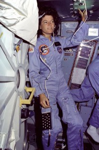 On Challenger's middeck, mission specialist Sally Ride, wearing a communications headset, floats alongside the middeck airlock hatch. Ride became an astronaut by answering a help wanted ad placed by NASA on a Stanford University bulletin board.