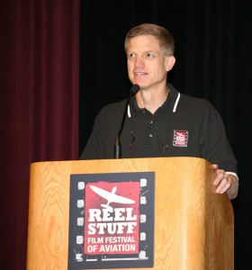 NAHF Executive Director Ron Kaplan, the founding director of the Reel Stuff Film Festival, addresses the audience before introducing Jim Farmer and Dean Hess for their co-presentation of “Battle Hymn” in the Dayton Convention Center theatre.