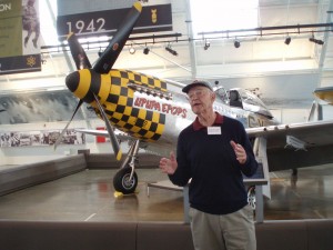 On opening day at the Flying Heritage Collection, Harrison “Bud” Tordoff, 82, tells visitors the P-51 behind him is the same plane he flew on bomber escort missions over Europe during WWII.