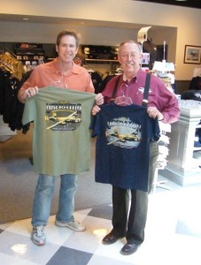 Steve Brown (left) and Lyn Fite display T-shirts for sale in the CAF American Airpower Heritage Museum gift shop.