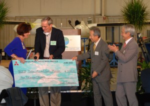 Katheryn Pennington, executive director of the Tulsa Air & Space Museum, accepted a check for $5,000 from Dennis Braner of Intercontinental Jet Service Center and Mitsubishi Heavy Industries America executives Noel Takayama and Eiichi Ishii.