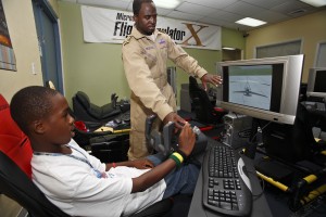 At his own Experience Aviation facility at Miami International Airport, Barrington Irving helps a student get his wings on a state-of-the-art flight simulator.