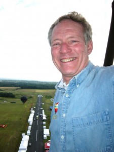 Balloon pilot Dick Young, wearing his perpetual smile, flies over the Solberg-Hunterdon Airport main runway, lined with festival tents and booths.