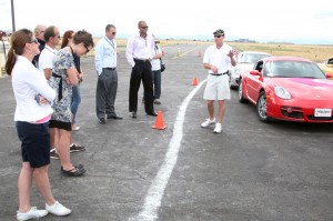 Cass Whitehead of the Porsche Driving School give instructions to the drivers that are about to take a couple of hot laps in the Porsche Cayman (APA).